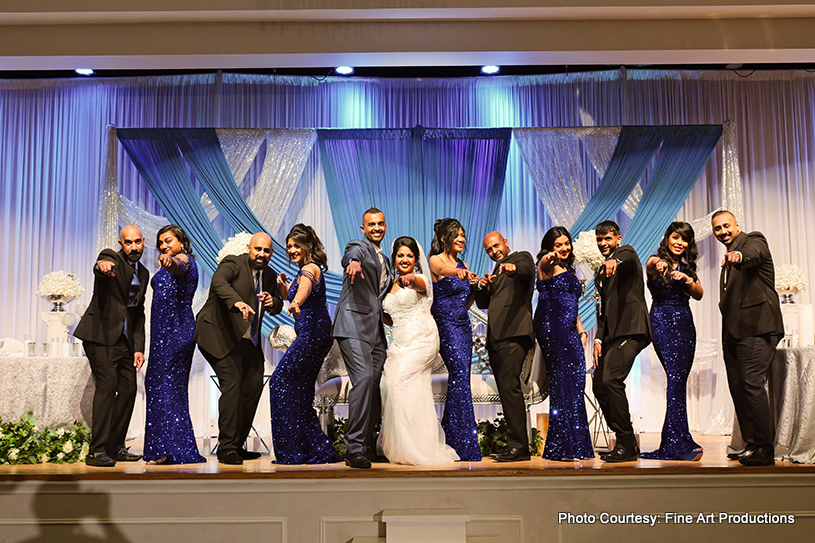 Indian newlyweds posing with bridesmaids and groomsmen 